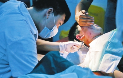 孩子身上有7道傷痕，其中兩道需要縫合，其他的均為擦傷，醫(yī)生正對(duì)他施治。