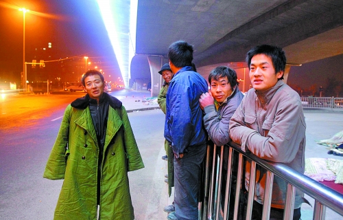 冬夜里，農(nóng)民工在橋下等著干活兒。