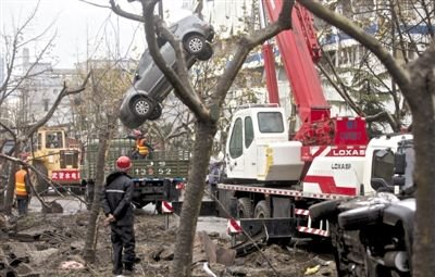 輸油管道爆炸后，搶修人員將被炸毀的車輛運出現(xiàn)場。