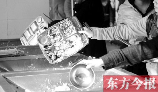 11月27日，河南中醫(yī)學(xué)院餐廳，一名同學(xué)將餐盤內(nèi)沒吃完的食物倒入餐具回收車內(nèi)