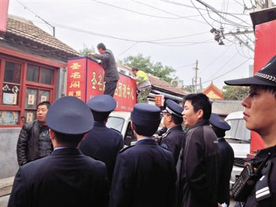 昨日下午,東城區(qū)工商、城管、公安等部門(mén),對(duì)雍和宮附近的預(yù)測(cè)中心進(jìn)行清理整頓,站在車頂?shù)膬擅と苏鸪患摇邦A(yù)測(cè)中心”的招牌。因雍和宮、白云觀等文化景點(diǎn)外聚集大量算命先生,被媒體稱為“算命一條街”。本版攝影/新京報(bào)記者 李寧 攝