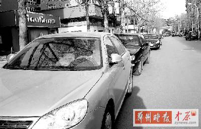 友愛(ài)路，路邊停了一排車，本來(lái)不寬的路就變得更窄了。