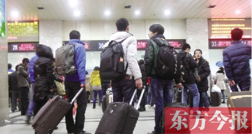 鄭州火車站東廣場售票大廳，幾名學(xué)生在售票窗口前躊躇