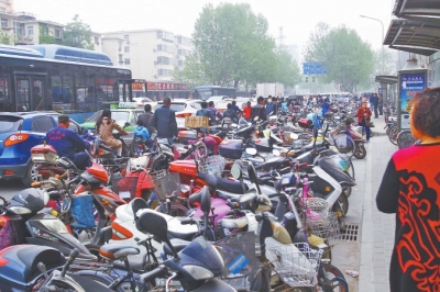 省人民醫(yī)院北門(mén)，路邊的公交站牌處停滿(mǎn)非機(jī)動(dòng)車(chē)，上、下客只能在快車(chē)道上。
