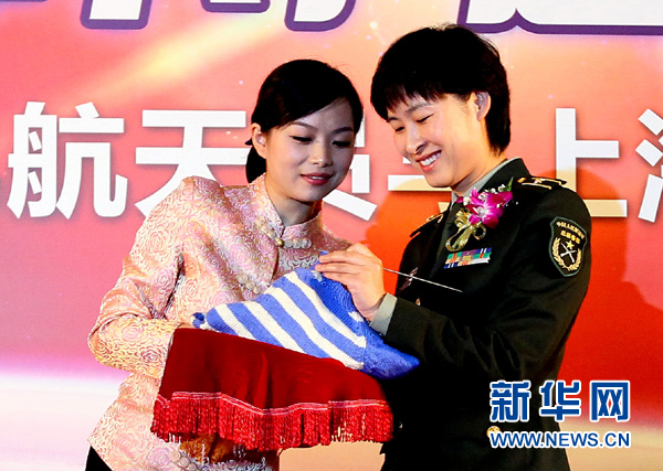 11月1日，航天員劉洋（右）在為“愛心”毛衣編織最后的收尾針。