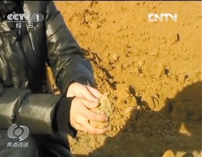 麻剛沙系麻剛石粉碎而成。記者找到一塊麻剛石，一捏就碎成粉末，硬度非常差。央視截圖