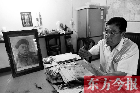 　魏樹(shù)紹手拿《物權(quán)法講義》手稿，在講訴先祖書(shū)寫(xiě)“物權(quán)法”的歷史（相框里就是魏聯(lián)奎）