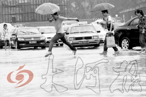 鄭州經(jīng)三路與北環(huán)交叉口處，積水較深，行人們不得不“練輕功”。 記者 白周峰 攝影