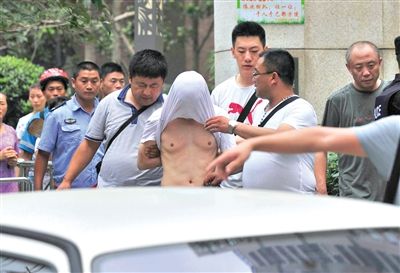 昨日，成都警方抓捕時與毒犯發(fā)生槍戰(zhàn)。一名男犯罪嫌疑人被警方押出。