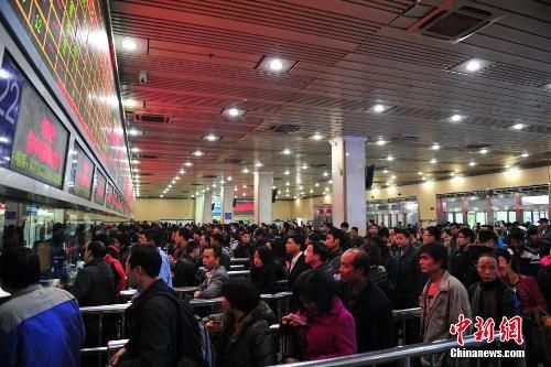 資料圖：12月25日，2014春運(yùn)臨客車票在廣州火車站開售，購(gòu)票市民在售票窗口前排起長(zhǎng)隊(duì)。中新社發(fā) 陳驥旻 攝