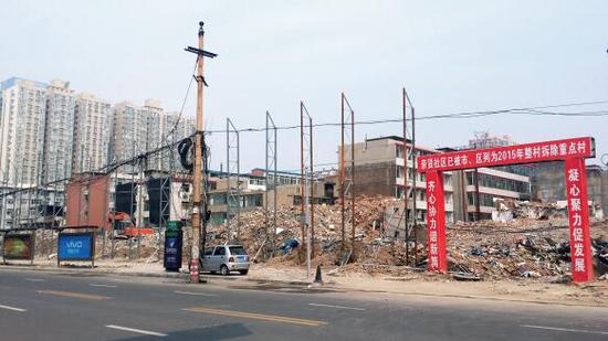 015年5月31日，在社區(qū)干部的帶頭拆遷下，親賢社區(qū)的“城中村改造”拉開帷幕。由于前期“清產核資”及補償標準等因素，拆遷改造工作推進并不順利。圖為位于體育西路東側集體所有的商鋪率先被拆遷完畢，用于遮擋的圍擋正在施工中。（拍攝：2015年9月16日）