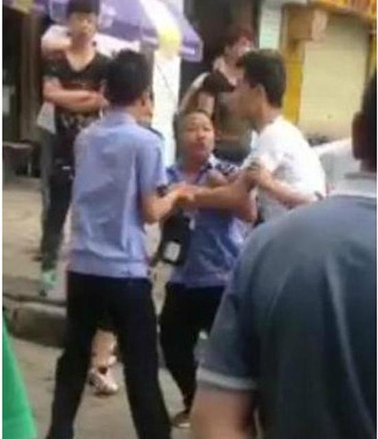 付某（右）與城管執(zhí)法人員廝打在一起。
