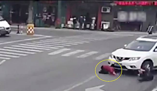 圖為小姑娘被卷進(jìn)車輪下瞬間。