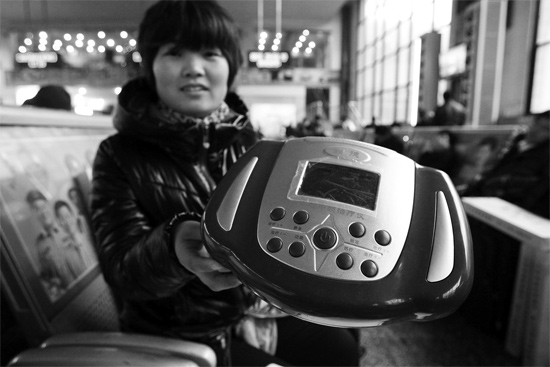 火車站候車室，李女士向記者展示她準(zhǔn)備孝敬父母的按摩儀