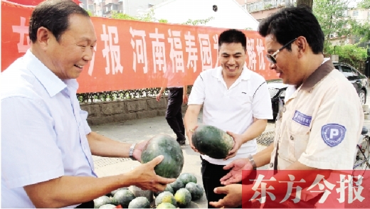 河南福壽園區(qū)域總經(jīng)理吳正宗（左一）、東方今報(bào)發(fā)行中心副總監(jiān)王路喜（中）在街頭給市民送瓜