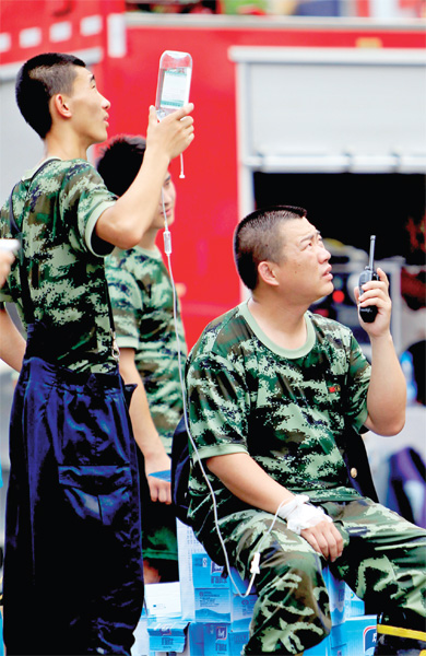 火場外，被消防戰(zhàn)士稱為“李大隊”的救援人員掛著吊瓶現(xiàn)場指揮
