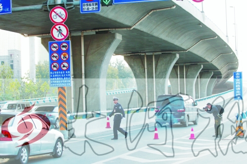 交警在東風(fēng)路從北向南上橋口處擺上反光錐，間歇放行