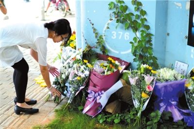 6月8日下午，記者來到廈門公交車爆炸事發(fā)現(xiàn)場橋下，附近已聚集了十幾個自發(fā)前來悼念的市民。橋墩下排放了一圈或黃或白的菊花，還有玖瑰、百合等。