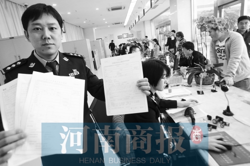 　民警左手拿的是新申請表，右手拿的是三份老申請表 王春勝/攝