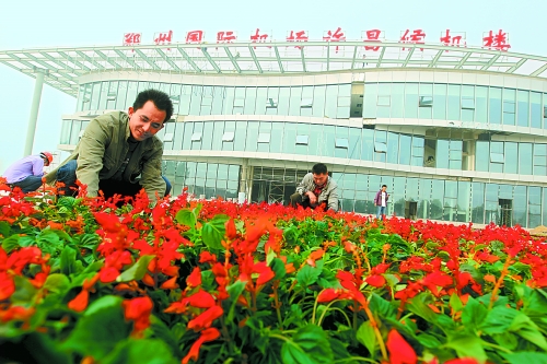 9月23日，工人們正在鄭州國際機場許昌候機樓前擺放鮮花。