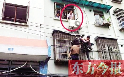 施救現(xiàn)場(chǎng)，劉鵬（圈內(nèi)）先用繩子捆住老太確保安全 勞動(dòng)報(bào)記者 郭娜 供圖