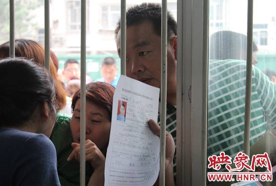 不少家長擠在報名窗口前咨詢報名事宜。