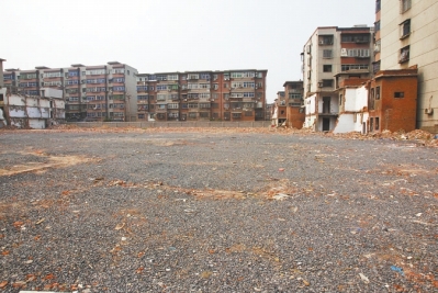 為降塵，旮旯王村拆遷后裸露的地面上鋪了一層石子。