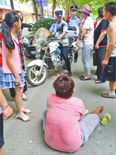 在鄭州優(yōu)勝南路東三街交叉口向東100米處，一名短發(fā)中年女子平躺在路南快車道上，身旁還有一只掉落的拖鞋