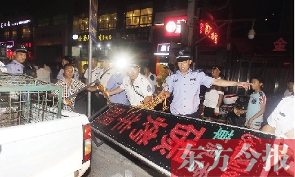 7月8日晚，鄭州市商城路一家占道經營的攤販招牌被執(zhí)法隊員“登記保存”
