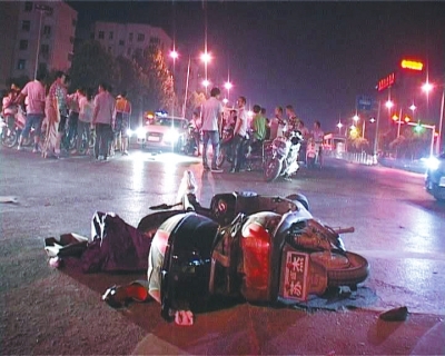 一輛白色無牌奧迪轎車在通過路口時(shí)，將一名騎電動(dòng)車的女子撞飛十多米