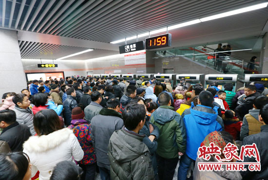 地鐵開通首日，上午十一點五十九分，紫荊山地鐵站售票機前擠滿了買票的市民。
