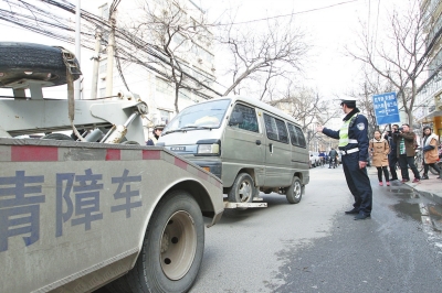 聯(lián)合執(zhí)法人員將市民舉報(bào)的違法占道經(jīng)營(yíng)車(chē)輛拖走暫扣