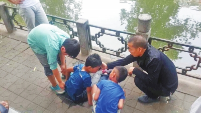 男孩被救出后，圍觀群眾幫他控水換衣服。