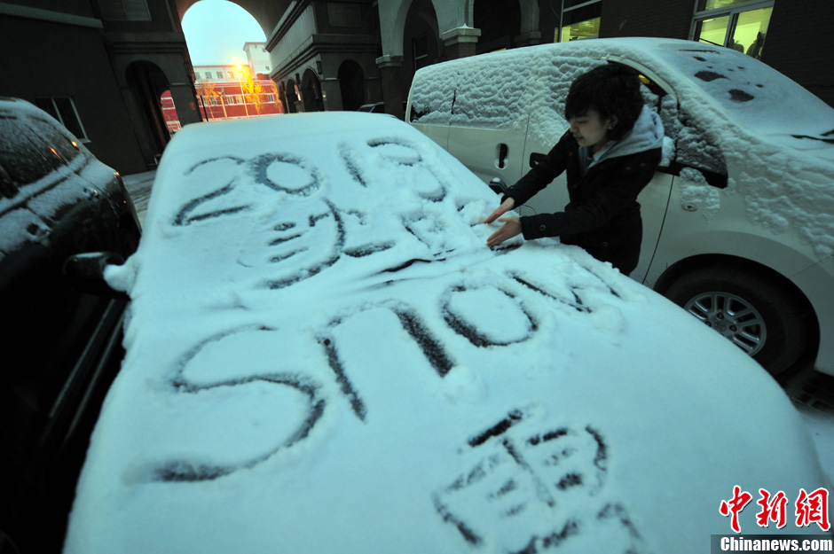 11月18日，行人在車輛的積雪上涂鴉。