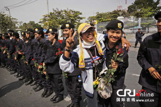 2013年12月03日,曼谷總理府與曼谷警署允許反政府示威民眾進(jìn)入,雙方進(jìn)入暫時“停戰(zhàn)”狀態(tài)迎接泰王生日。曼谷警察總署,女警們手持鮮花送給反政府示威民眾。圖片來源:Manish Swarup/東方IC