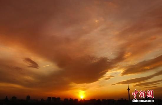 12月8日下午，強(qiáng)烈的西北風(fēng)光臨北京，吹散了籠罩全城上空的霧霾，冬日罕見的艷麗晚霞映紅了半邊天。