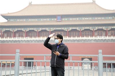 11月1日，北京大部分地區(qū)重度污染，一名游客戴著口罩在午門前揮手跟朋友打招呼。 實(shí)習(xí)生 王飛 攝