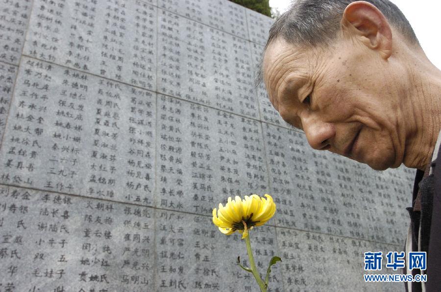 2006年4月5日，74歲的南京大屠殺幸存者佘子清手捧鮮花，祭奠被日軍殺害的母親。