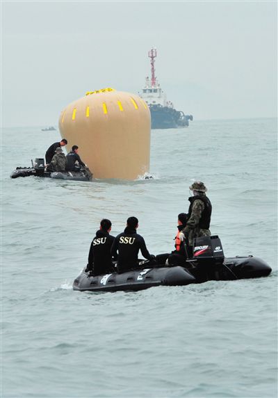 18日，搜救人員準備將氣囊捆綁到沉沒客輪上。