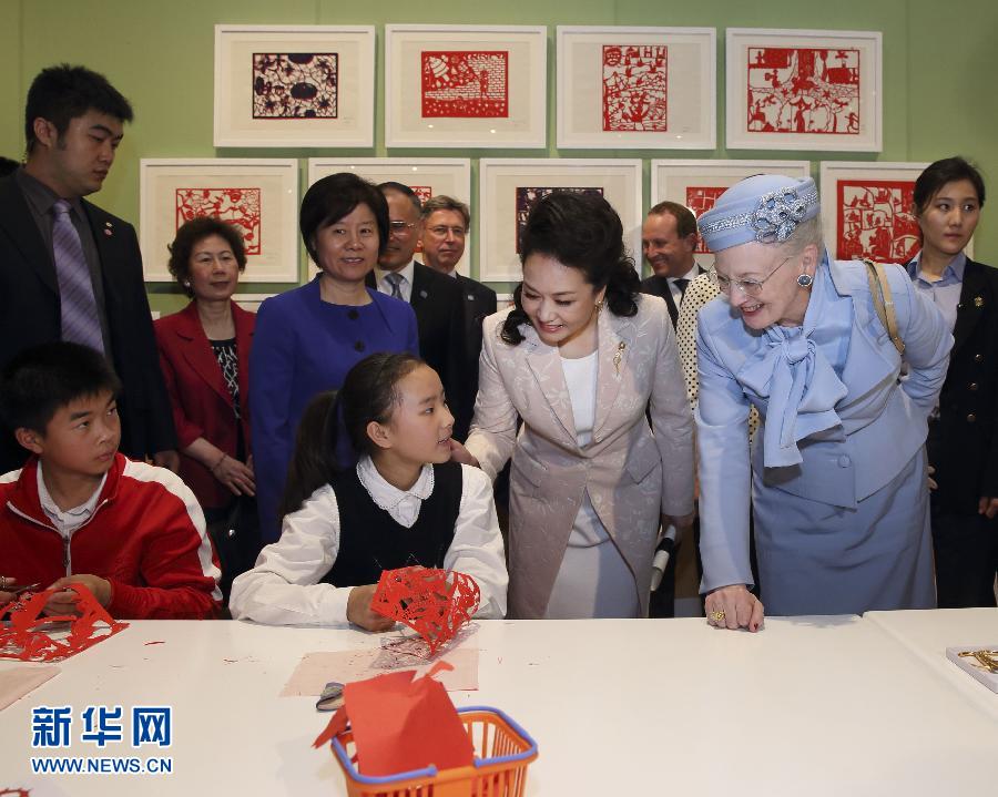 這是彭麗媛和瑪格麗特二世與根據(jù)安徒生童話中人物和情節(jié)制作剪紙的孩子交談。