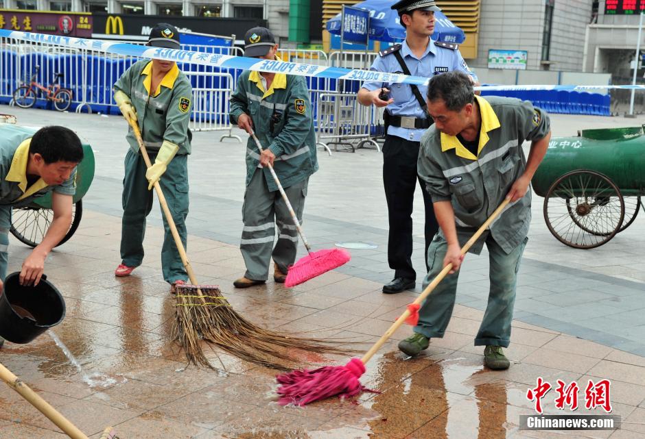 圖為環(huán)衛(wèi)工人在清理案發(fā)地點的血跡。