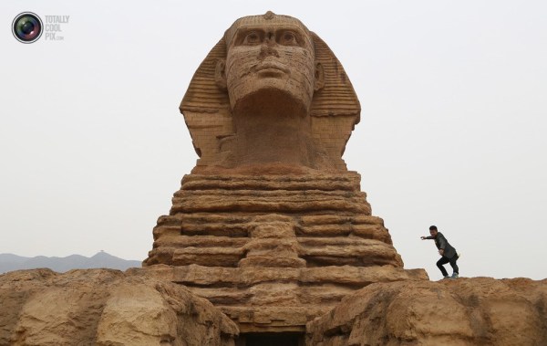 石家莊郊外，一名男子與山寨版獅身人面像合影留念。