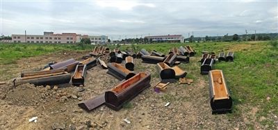 40多副棺木被砸壞后，扔在荒地上。
