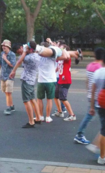 　四名外籍男子一同扛起醉漢拍照。