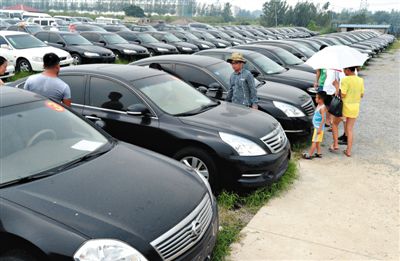昨日，市民在山東棗莊一家拍賣公司場地上查看待拍賣公車。當日，棗莊市103輛公車公開拍賣。新華社記者