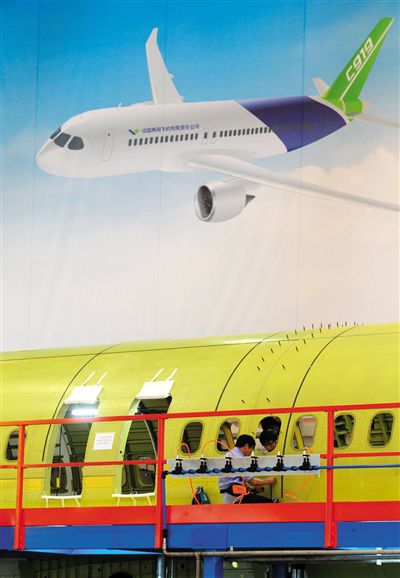 昨日，中國商飛總裝制造中心技術人員對接C919首架機的機體。新華社記者 丁汀 攝