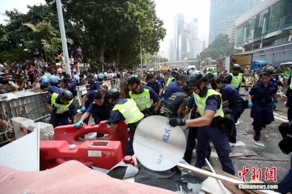 10月14日，警方清除金鐘道障礙物。大批警員在金鐘道現(xiàn)場清拆障礙物。部分警員戴上頭盔將障礙物移走。