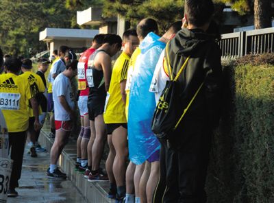 2013年10月20日，北京馬拉松比賽，由于廁位有限，一些選手在綠化帶“就地解決”。圖/IC