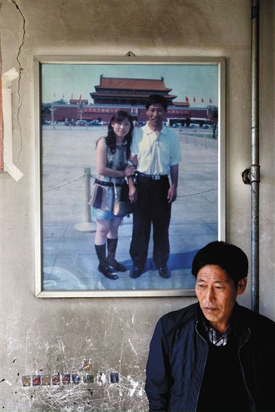 11月14日，承德市平泉縣，潘小梅父母的家，潘小梅父親靠在墻上，身后掛著數(shù)年前他和潘小梅在北京的合影照片。新京報記者
