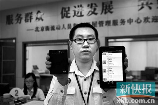 　越秀區(qū)北京街出租屋外來暫住人員管理服務(wù)中心的工作人員展示到出租屋登記來穗人員信息的儀器。